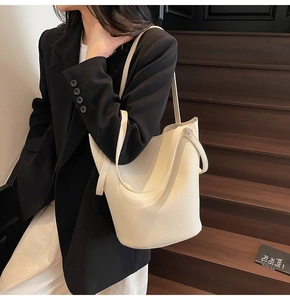 Detail of off-white lychee pattern bucket bag showing supple leather texture and metal buckle