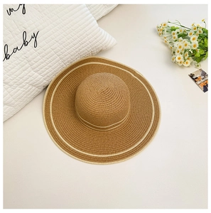 Vista superior de un sombrero de paja tejido con rayas blancas sobre fondo de estilo de vida