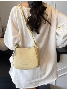Minimalist light yellow lychee pattern leather bucket bag with knotted strap and pendant