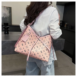 Detailed shot of large pink leather tote with cartoon bear prints on a female model