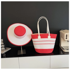 Détail d'un chapeau de soleil en paille à rayures rouges et blanches avec sac assorti