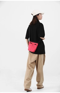 Dettaglio della borsa a tracolla in nylon rosso con cinghia regolabile e tasche