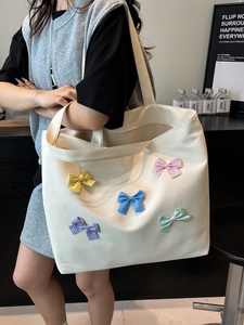 Canvas tote bag with colorful bows shown on model shoulder for casual daily style