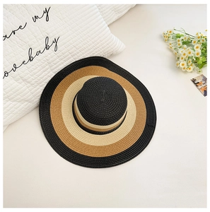 Vista de detalle de sombrero de paja de ala ancha con diseño concéntrico tricolor bohemio