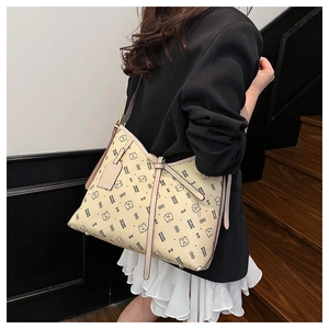 Detail of a beige tote bag featuring bear patterns and a stylish bow knot accessory