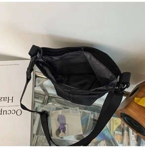 Dettaglio dell'interno della borsa a tracolla in nylon con fodera grigia e chiusura a scatto