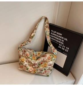 Detail view of 3D cartoon bear patches and floral textures on cream crossbody tote bag