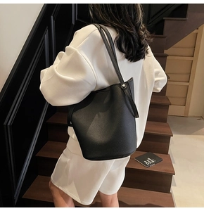 Close-up of matte black pebble leather bucket bag with silver metal stud hardware details