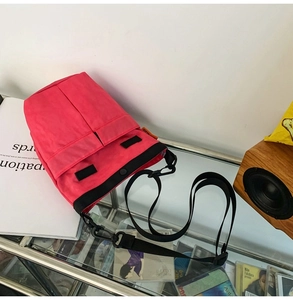 Vista dall'alto della borsa a tracolla in nylon rosa con tasca in velcro nera e cinturino