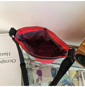 Dettaglio interno della borsa a tracolla in nylon rosa con chiusura a scatto e cinghia