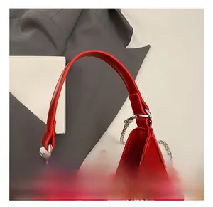 Détail de la poignée du sac à main en cuir verni rouge avec finition brillante et argent