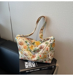Close-up of 3D embossed cartoon bear and flower patterns on beige leather tote bag