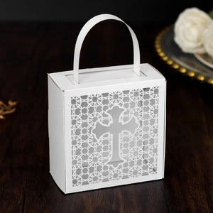Macro view of white laser-cut gift box with hollow cross design and integrated handle