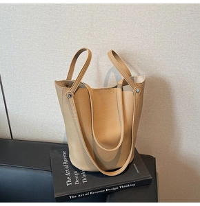 Detailed close-up of camel litchi grain leather bucket bag with silver rivet hardware