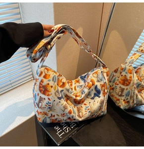 Detail of canvas hobo bag with cartoon forest animal print and adjustable strap