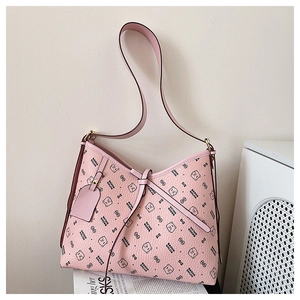 Detail of pink faux leather bag featuring bear prints and polished gold hardware