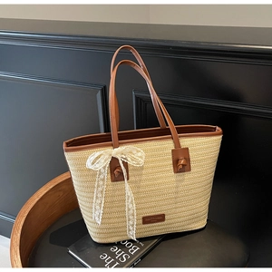 Détail de la texture en paille tressée blanche avec bordure cuir marron et nœud dentelle