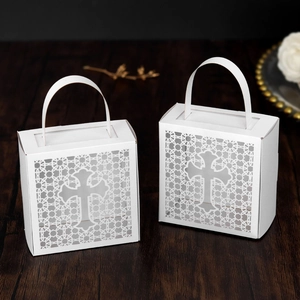 Macro detail of white laser-cut cross hollow candy box on wood background for weddings