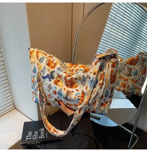 Detail of cartoon animal print tote bag with adjustable strap shown in mirror reflection