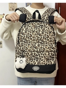 Close-up of leopard print backpack with bear charm and reinforced black bottom base