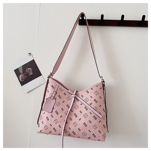Detail of pink shoulder bag featuring bear and letter prints with lychee texture leather
