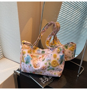 Detail of pink shoulder bag featuring 3D cartoon bear and floral prints with adjustable strap
