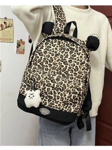 Detail of leopard print backpack with cat ears and white plush doll charm