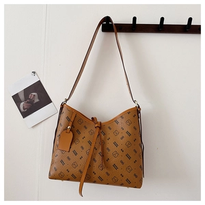 Detail of a brown leather shoulder bag featuring cartoon bear patterns and decorative knot