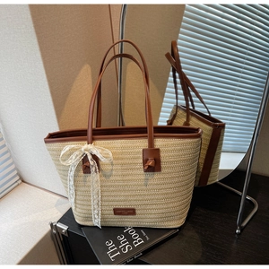 Détail du sac cabas en paille tissée avec poignées en cuir et décoration en dentelle