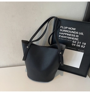 Detail of classic black lychee-textured leather bucket bag with soft grain and silver studs