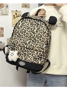 Detail of leopard print backpack with cute bear ears and plush charm accessory