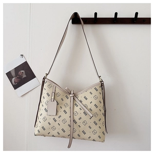 Detailed view of beige hobo bag featuring bear print and litchi grain leather texture