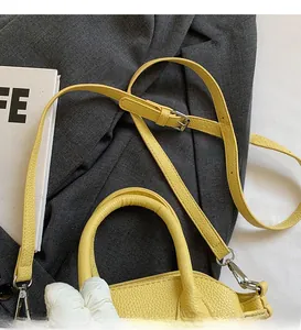 Detail of yellow lychee texture shell bag with adjustable long shoulder strap and hardware