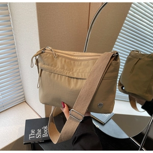 Detail of khaki multi-pocket tote bag with nylon texture and adjustable wide strap