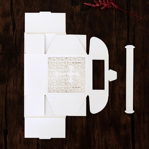 Detailed laser-cut white cross favor box template with intricate lace patterns