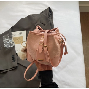 Pink crocodile texture bucket bag with drawstring closure and soft white faux fur pompom