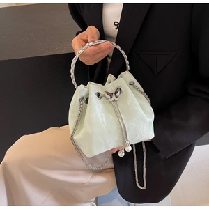 Détail du sac seau vert menthe avec boucle papillon argentée et cordons ornés de perles