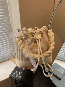 Chic cream leather and straw woven bucket bag with pearl charm for summer fashion
