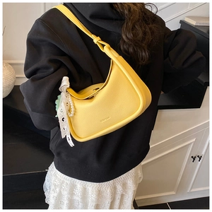 Gelbe Halbmond-Schultertasche aus genarbtem Leder mit Perlen-Spitzen-Anhänger am Model