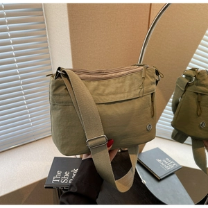 Detail of khaki nylon crossbody bag with adjustable wide strap and metallic logo