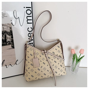 Detail of light beige hobo bag featuring all-over bear print and pebbled leather texture