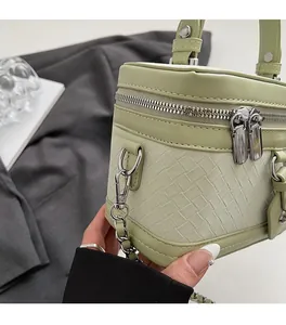 Détail du sac en cuir tressé vert matcha avec fermeture éclair et chaîne en argent