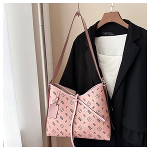 Detail of pink lychee leather handbag with black bear print on a black blazer