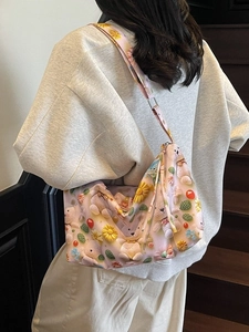 Pink cartoon teddy bear tote bag with wide shoulder strap worn by model on stairs