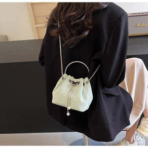 Détail du sac seau vert menthe avec poignée anneau argentée et pendentifs perles