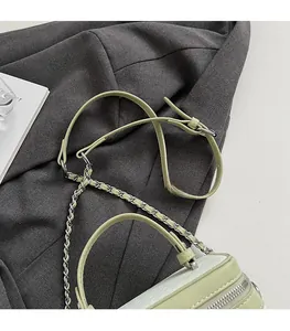 Détails de la bandoulière réglable et motif crocodile sur le sac box vert menthe