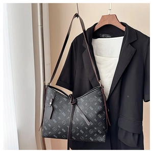 Detail of black pebbled leather tote featuring white letter print and cute bear pattern