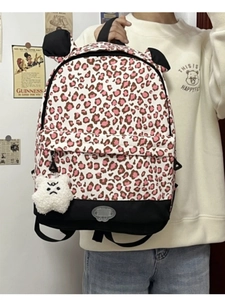 Detail of leopard print backpack with plush star charm and cute animal ears design