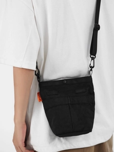 Piccola borsa a tracolla in nylon nero con tracolla regolabile ed etichetta arancione