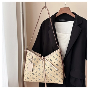 Detail of beige shoulder tote bag with bear patterns and bow on a wooden hanger